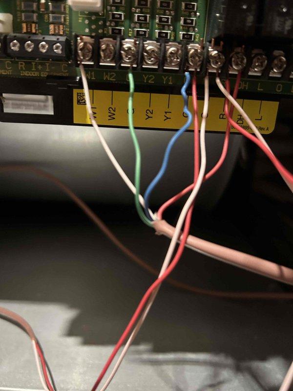 Responded to no cooling complaint on five-year-old air conditioning system. Upon arrival, inspected indoor unit control board and thermostat wiring connections at terminal strip. Verified proper wire terminations at Y1, Y2, R, C, and W2 terminals, checked for loose connections or damaged wiring. Documented control board configuration and wiring setup with photos for service records. System evaluated and appropriate recommendations provided to restore cooling operation.