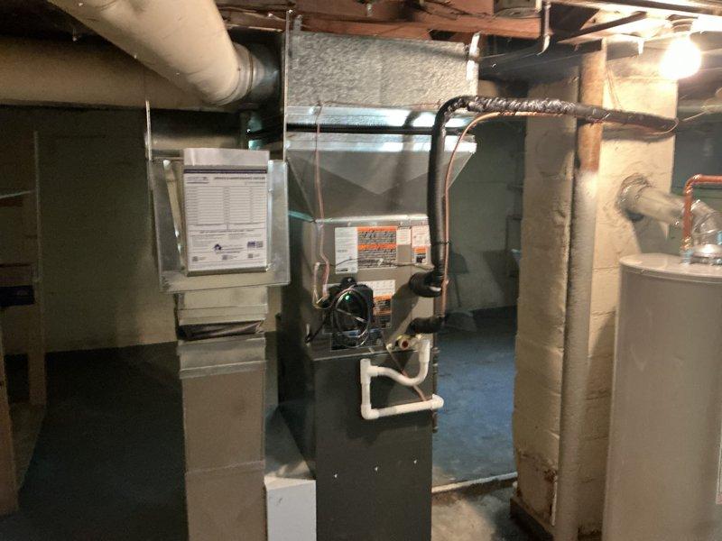Completed installation of 2-ton air conditioning system with evaporator coil in basement mechanical room. New outdoor condensing unit positioned in rear yard and reconnected to existing furnace system. All refrigerant lines, electrical connections, and condensate drainage installed per manufacturer specifications and local mechanical permits obtained prior to installation.