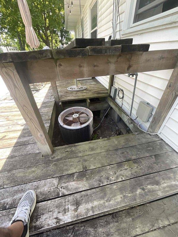Conducted comprehensive on-site assessment for complete HVAC system replacement at residential property with 20+ year-old non-operational equipment. Evaluated existing natural gas furnace located in basement and air conditioning condenser unit installed in recessed compartment beneath exterior deck structure. Documented current equipment configuration, including unique deck-mounted AC installation with built-in access hatch, electrical connections, and refrigerant line routing. Provided detailed replacement estimate for new furnace and air conditioning system to restore climate control functionality.