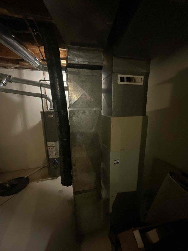 Provided estimate for replacement of 28-year-old non-functional HVAC system located in basement, including both furnace and air conditioning unit. Customer primarily interested in air conditioning replacement but requested information on buy-one-get-one promotion for complete system upgrade. Documented existing Bryant furnace installation with connected ductwork, air handler, and filter cabinet for accurate equipment sizing and replacement specifications.