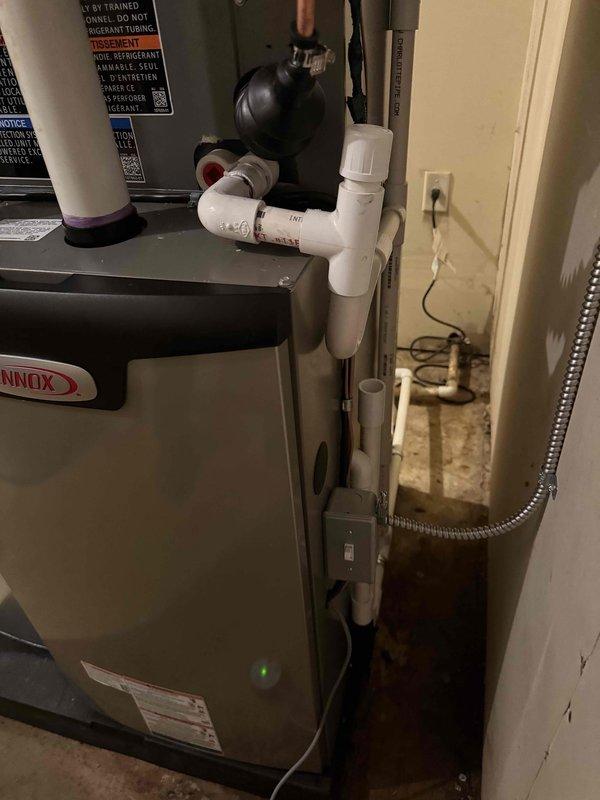 Completed full HVAC system installation including a Lennox 70,000 BTU high-efficiency condensing furnace, 2-ton air conditioning unit, and hot water heater in residential basement utility room. Installed complete PVC venting system for furnace exhaust and intake, copper refrigerant lines, flexible gas line connection, and black expansion tank with associated plumbing connections and pressure relief components. All mechanical equipment reconnected, tested, and operational per manufacturer specifications with proper permits obtained.