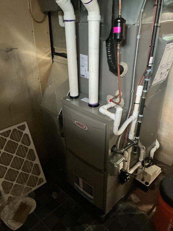Completed routine Air Care Maintenance on Lennox HVAC system in residential basement utility room. Performed comprehensive inspection of furnace unit, verified proper operation of intake and exhaust venting through dual PVC pipes, checked copper refrigerant line connections, and inspected condensate drainage system for proper flow and functionality. All components operating within normal parameters with no issues identified.