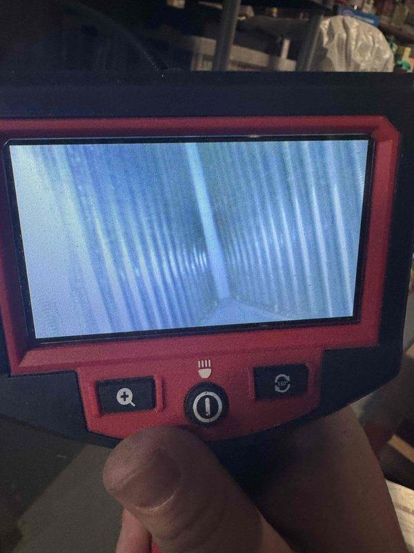Responded to no cooling complaint on 4-year-old Lennox system. Upon arrival, found ice buildup on refrigerant lines at evaporator coil connection, indicating restricted airflow or low refrigerant charge. Thermostat was calling for cooling and indoor blower was operating, but minimal air delivery through supply registers confirmed airflow restriction. Performed system diagnostics using inspection camera to assess evaporator coil condition and verified blower operation. Identified frozen evaporator coil as primary issue preventing proper cooling. System shut down to allow coil to thaw completely before proceeding with further diagnostics to determine root cause of icing condition, whether due to dirty filter, blocked return air, low refrigerant charge, or failed blower motor capacitor.