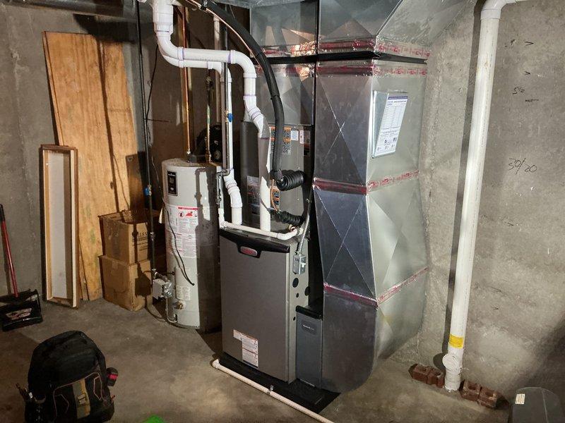 Completed full HVAC system installation in basement mechanical room, including 90,000 BTU furnace and 3-ton air conditioning unit configured for left-side positioning. Installed new air handler with proper refrigerant line connections, condensate drainage system using white PVC piping, and all required electrical connections. All mechanical and electrical permits obtained and system reconnected to existing ductwork per specifications.