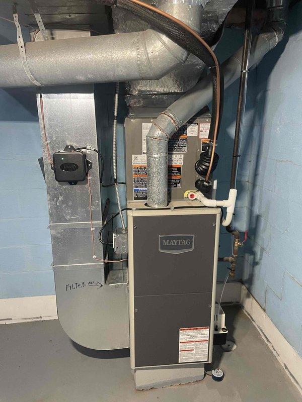 Completed air conditioning equipment installation in basement mechanical room. Connected refrigerant lines to existing furnace system, installed ductwork routing, and completed all electrical connections. System tested and verified operational with proper airflow through filter cabinet and air handler unit.