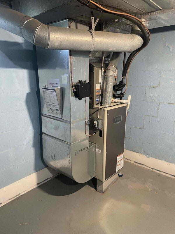 Completed air conditioning equipment installation in basement mechanical room. Connected refrigerant lines to existing furnace system, installed ductwork routing, and completed all electrical connections. System tested and verified operational with proper airflow through filter cabinet and air handler unit.