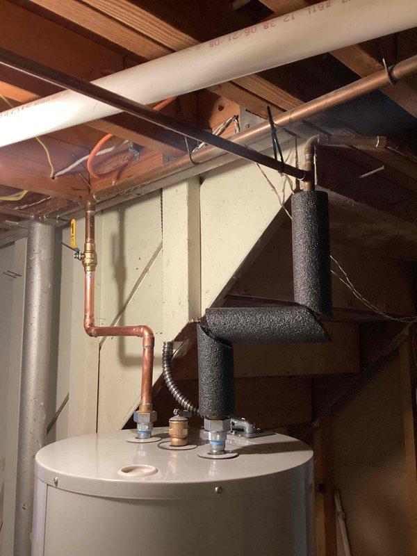 Completed full HVAC system replacement including installation of 70,000 BTU gas furnace, 2-ton air conditioning unit with left-side configuration, and residential water heater in basement utility area. All equipment was properly connected to existing ductwork, plumbing lines, and electrical systems with copper piping, brass fittings, PVC venting, and insulated refrigerant lines installed per manufacturer specifications and local mechanical code requirements.