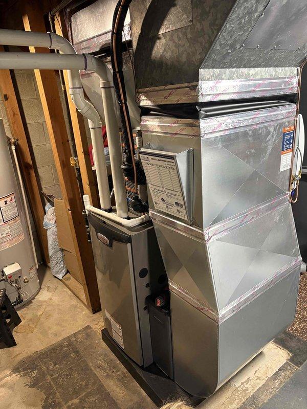 Completed full HVAC system installation including a 70,000 BTU furnace, 1.5 ton air conditioning unit with rear discharge configuration, and humidifier in basement utility area. All ductwork connections were secured, equipment was reconnected to existing infrastructure, and system was tested for proper operation. Permits were obtained prior to installation and all work was completed to code specifications.