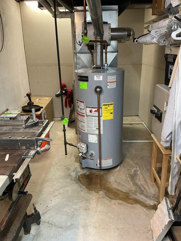 Completed annual cooling maintenance inspection on HVAC system. Unit was found to be operating within normal parameters with no immediate service needs identified. Documented equipment condition with photographic records showing water heater and associated plumbing connections in basement utility area, noting minor floor staining consistent with normal condensate drainage patterns.