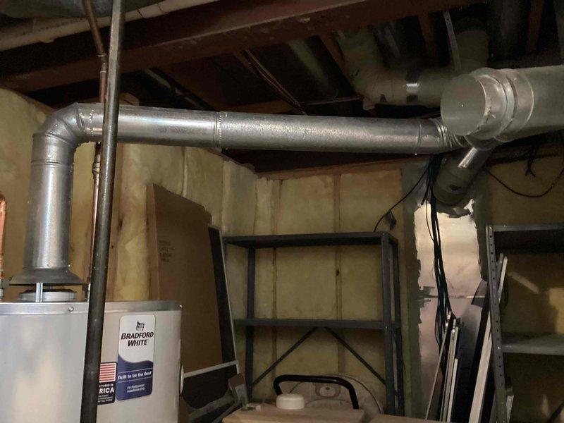 Successfully installed a 75-gallon Bradford White tanked water heater in basement utility area. Completed all necessary plumbing connections including copper supply lines with shut-off valves, proper venting with metallic vent pipe extending to code-compliant termination point, and reconnection of all water supply systems. Installation performed in accordance with mechanical permit requirements and manufacturer specifications.