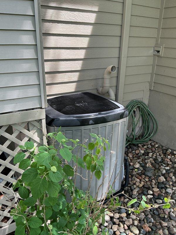 Completed annual cooling maintenance on residential HVAC system. Inspected outdoor condensing unit with cylindrical design, verified proper operation and clearance from surrounding vegetation and debris. Examined indoor air handler components including humidifier pad assembly, noting moderate dust accumulation and discoloration on mesh filter media. Checked refrigerant line connections and condensate drainage system. Unit operating within normal parameters with no immediate service concerns identified.