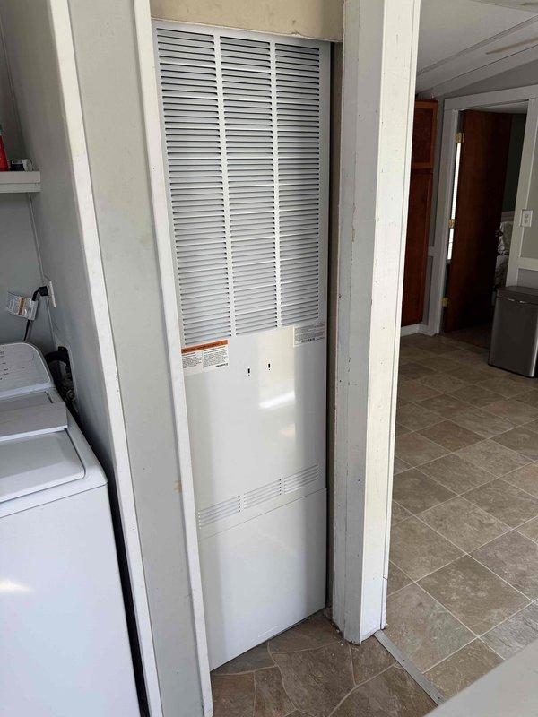 Completed installation of 2-ton air conditioning system with evaporator coil in residential utility closet. Installed new furnace unit in recessed alcove adjacent to laundry area, mounted on tile flooring with proper clearances maintained. Established new dedicated electrical circuit on right side of unit to meet code requirements. Obtained mechanical, electrical, and air conditioning permits prior to installation. System installed, tested, and operational.