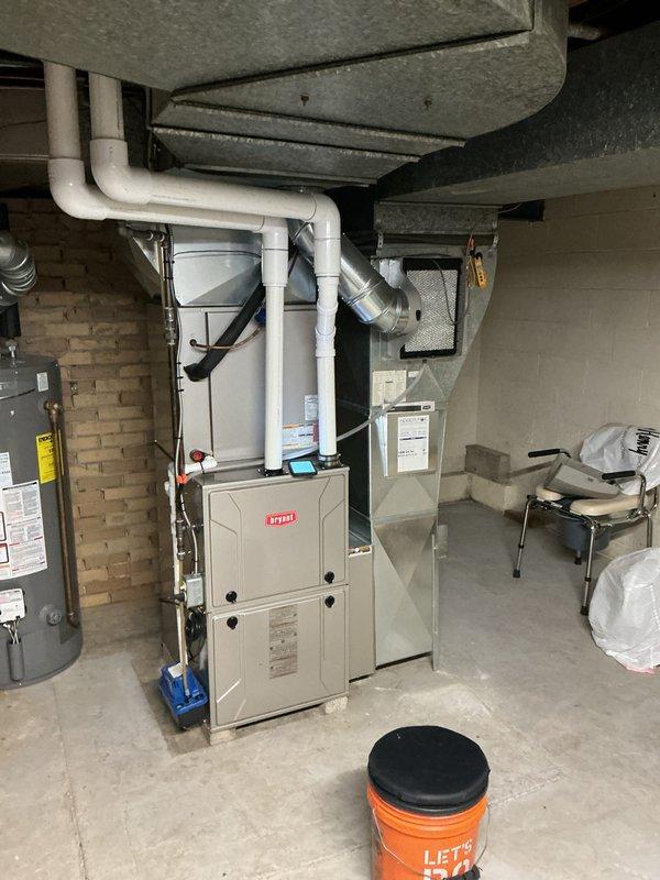 Completed annual cooling maintenance on Bryant HVAC system. Inspected furnace unit, ductwork connections, and PVC condensate drainage system. Replaced heavily soiled humidifier filter pad showing significant mineral deposit buildup in lower section. All mechanical components, electrical connections, and refrigerant lines inspected and found operating within normal parameters.