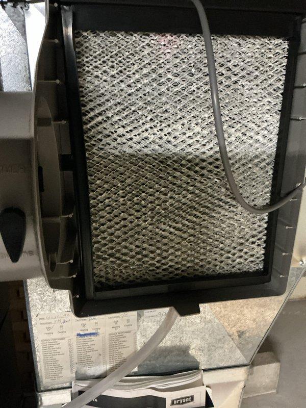 Completed annual cooling maintenance on Bryant HVAC system. Inspected furnace unit, ductwork connections, and PVC condensate drainage system. Replaced heavily soiled humidifier filter pad showing significant mineral deposit buildup in lower section. All mechanical components, electrical connections, and refrigerant lines inspected and found operating within normal parameters.