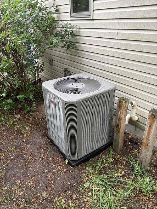 Completed full HVAC system installation including a 70,000 BTU furnace and 3-ton air conditioning unit with rear discharge configuration. The outdoor condenser was positioned on a concrete pad with proper base support against the exterior wall, and all refrigerant lines and electrical connections were established. Interior mechanical components were installed with condensate drainage routed to existing floor drain, all necessary permits obtained, and system reconnected and tested for proper operation.