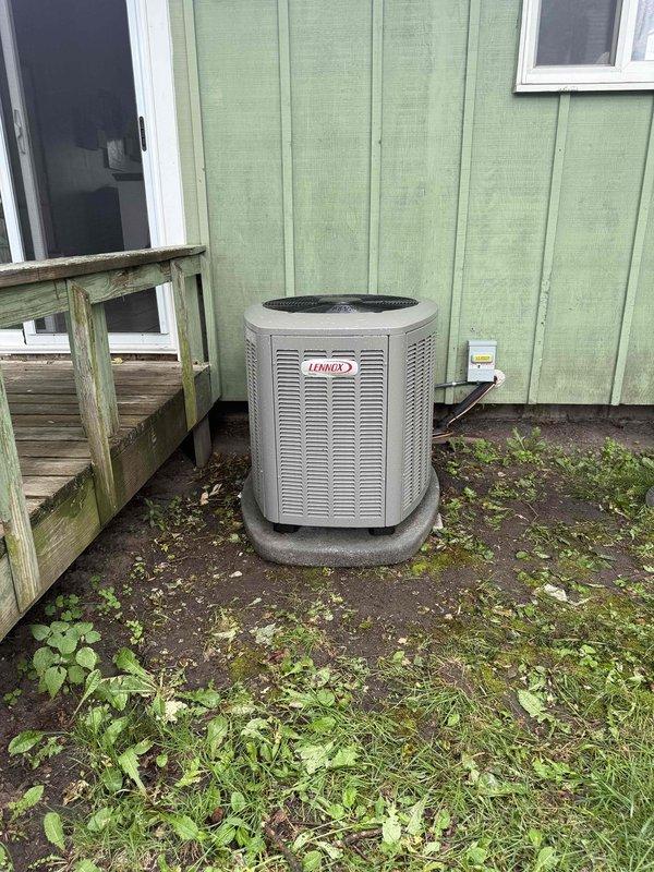 Completed full HVAC system installation including a 70,000 BTU gas furnace with humidifier and 2.5-ton Lennox air conditioning unit. The outdoor condensing unit was positioned on an existing concrete pad at the rear of the residence with refrigerant lines routed along the building exterior and electrical disconnect box mounted to exterior wall. All equipment was installed per manufacturer specifications, refrigerant lines were insulated and properly connected, and existing ductwork reconnection was completed to integrate the new furnace into the home's heating and cooling distribution system.