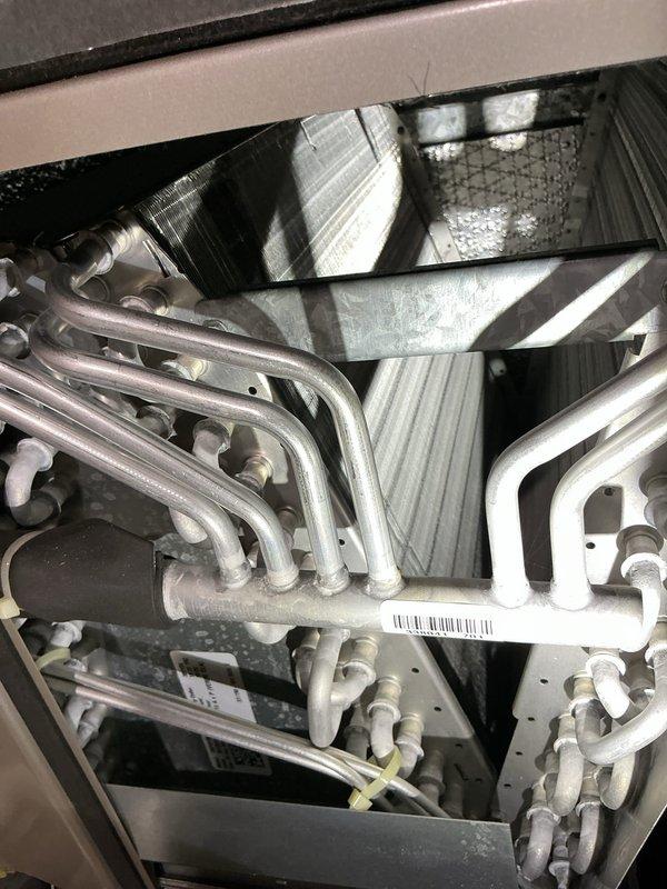 Completed comprehensive A/C tune-up on 13-year-old system. Performed visual inspection of evaporator coil, noting frost accumulation on refrigerant lines indicating proper cooling cycle operation. Verified electrical performance at outdoor condensing unit with multimeter readings confirming adequate voltage supply at 345.7 volts. All system components operating within normal parameters at time of service completion.