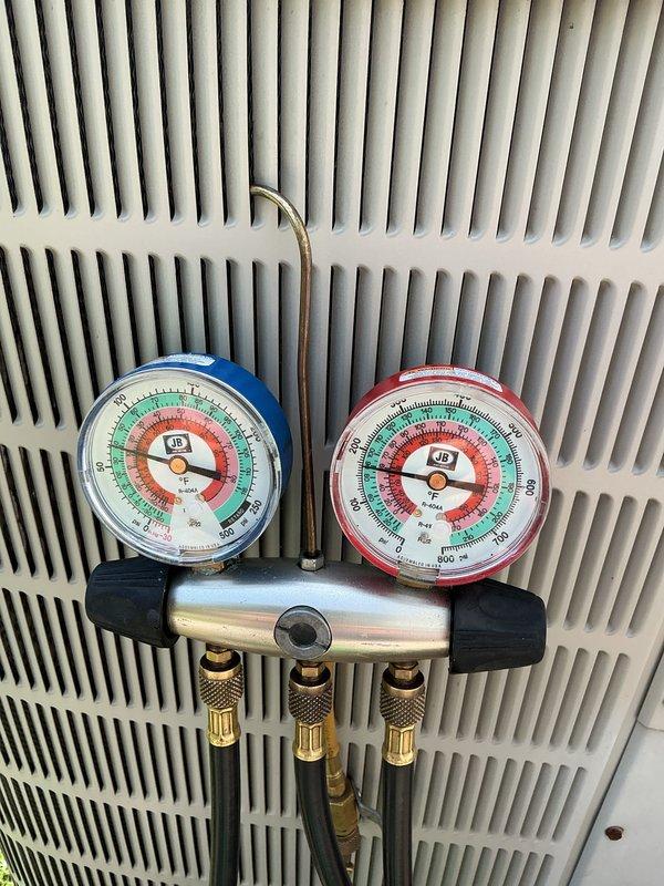 Completed annual air conditioning maintenance inspection. Connected manifold gauges to measure refrigerant pressures and verify system operating within manufacturer specifications. Inspected outdoor condenser unit, refrigerant line connections, and service valves for proper operation and secure fittings.