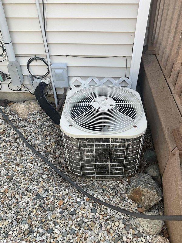 Assessed 28-year-old residential air conditioning system with severely diminished cooling capacity, running continuously but only reducing indoor temperature by one degree over eight hours with discharge air barely below ambient room temperature. Documented existing outdoor condenser unit showing significant age-related deterioration and weathering, with refrigerant lines and electrical connections intact. Provided replacement estimate for complete system due to age and inefficient operation beyond economical repair.