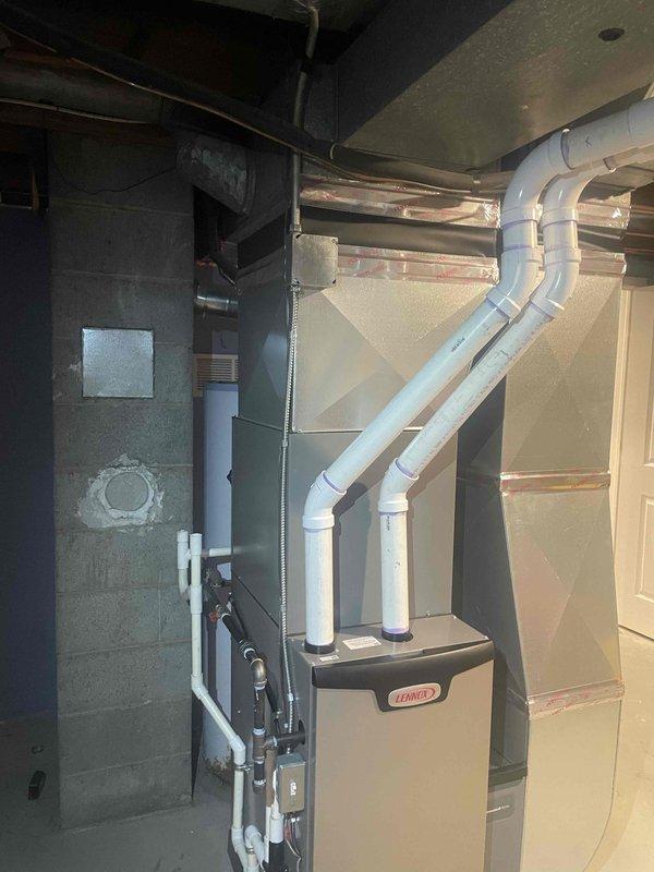 Completed full HVAC system installation including a 70,000 BTU Lennox furnace and 2-ton air conditioning unit in basement mechanical room. Installed proper PVC venting with U-bend configuration extending through exterior wall, connected all ductwork to existing distribution system, and established rear-mounted condensing unit connections. All mechanical permits obtained, equipment properly positioned and secured, utility reconnections completed, and system tested for proper operation.