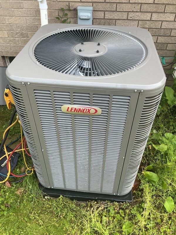 Responded to service call for Lennox outdoor condensing unit experiencing abnormal noise during operation. Performed comprehensive Air Conditioning Maintenance (ACM) on one-year-old system under parts and labor warranty. Inspected condenser unit, cleared vegetation growth from base and around lower louvers, verified fan operation and electrical connections, and documented equipment condition with photographic evidence of unit exterior and installation location.