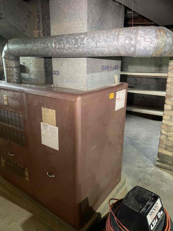 Conducted comprehensive assessment of existing HVAC system in single-family residence for full system replacement estimate. Evaluated 50-year-old furnace unit located in basement with brown-painted exterior cabinet, existing ductwork infrastructure with reflective insulation, and supply air plenum connections. Documented current equipment specifications, measured existing duct configurations, and assessed mechanical room layout including foundation conditions and available installation space. Provided detailed recommendations for new high-efficiency furnace installation and addition of split-system central air conditioning to ensure reliable heating and cooling operation prior to winter season. Photographed existing equipment, ductwork routing, thermostat location, and electrical components to support system design and installation planning.