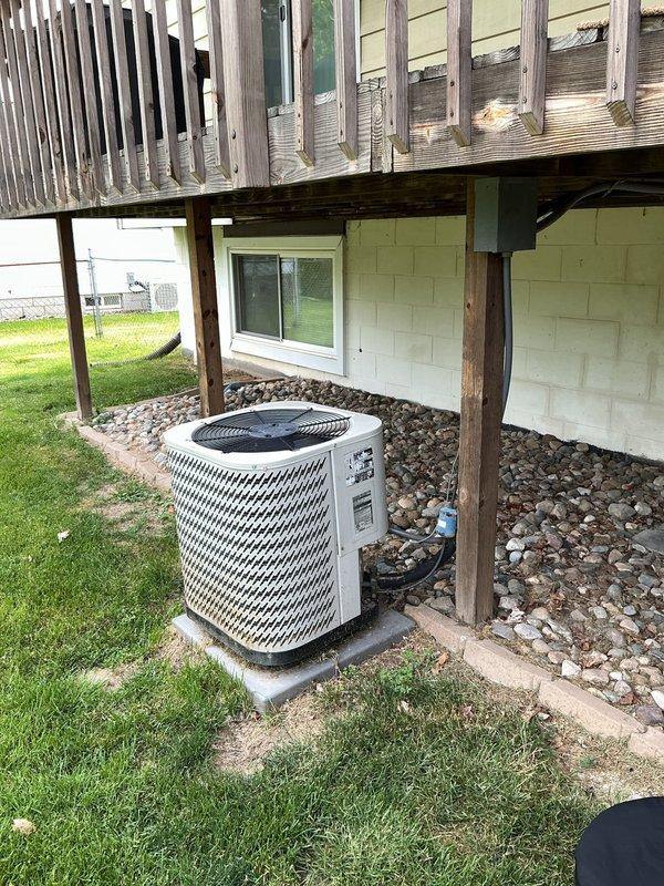 Responded to no cooling complaint on 14-year-old residential air conditioning system that had received 3 lbs of refrigerant charge from another contractor one month prior. Performed comprehensive diagnostic evaluation of outdoor condensing unit and indoor air handler to provide second opinion after previous company deemed system unrepairable. Conducted visual inspection of outdoor unit located beneath elevated deck, checked refrigerant pressures, tested compressor operation, inspected evaporator coil accessibility at furnace location, and evaluated overall system performance. Identified active refrigerant leak causing recurring loss of charge and inadequate cooling capacity. Assessed condition of aging components including compressor, coil integrity, and refrigerant line connections. Documented findings with photographic evidence of equipment placement and installation conditions. Provided customer with detailed explanation of diagnostic results, repair options, and professional recomm