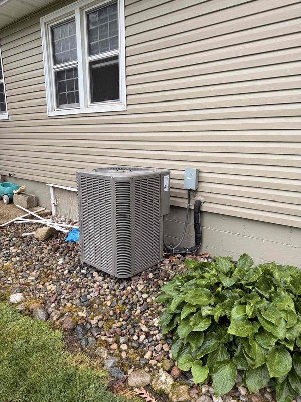 Completed full HVAC system replacement on 1,412 square foot residential property built in 1967. Installed new 70,000 BTU furnace with 2-ton air conditioning unit configured for rear discharge. Replaced outdoor condenser unit, positioned on rock bed against foundation with proper clearance and mounting. Installed gray electrical disconnect box on exterior wall with appropriate conduit and wiring connections from AC unit. Secured mechanical permit for furnace and AC installation work. Reconnected all electrical and refrigerant lines to new equipment. Verified proper insulation on refrigerant lines. System tested and operational upon completion. Five-year warranty protection activated with installation. Utility rebate documentation processed.