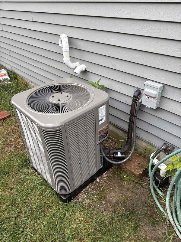 Completed full 2-ton air conditioning system installation including outdoor condensing unit and indoor evaporator coil. Installed new condenser on concrete pad with proper refrigerant line connections, electrical disconnect, and PVC condensate drain routing along exterior siding. Connected indoor coil to existing ductwork in basement mechanical area with appropriate refrigerant piping and drainage. System tested, charged to manufacturer specifications, and verified operational.