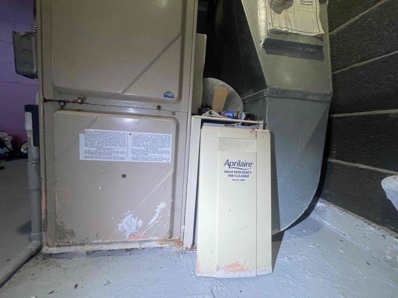 Completed comprehensive assessment of 26-year-old Amana furnace and air conditioning system for full replacement estimate. Documented existing basement installation including dual furnace configuration, Aprilaire Model 2401 high efficiency air cleaner, PVC venting system, and outdoor condensing unit. Photographed current equipment condition, ductwork layout, and mechanical room configuration to provide accurate replacement specifications for expedited system upgrade.