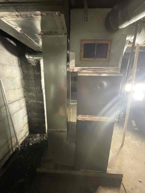 Provided estimate for complete replacement of non-operational furnace and hot water heater located in basement mechanical room. Both units are inoperable with unknown age, showing signs of extended service life in moisture-compromised environment with visible water damage and deterioration on surrounding concrete block walls. Assessed existing HVAC infrastructure including ductwork, venting systems, and utility connections to determine replacement requirements and proper equipment sizing for residential heating and domestic hot water needs.