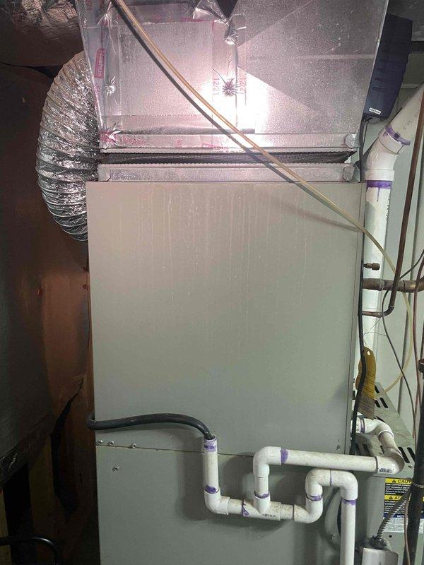 Completed on-site assessment and provided replacement estimate for aging air conditioning system over twenty years old. Evaluated existing HVAC equipment including outdoor condensing unit, indoor air handler, and associated ductwork and drainage systems in basement utility area. Documented current system configuration with comprehensive photographic documentation showing furnace/air handler unit, plenum connections, flexible and rigid ductwork, PVC condensate drain lines, and overall installation layout to support accurate replacement proposal for immediate system upgrade.