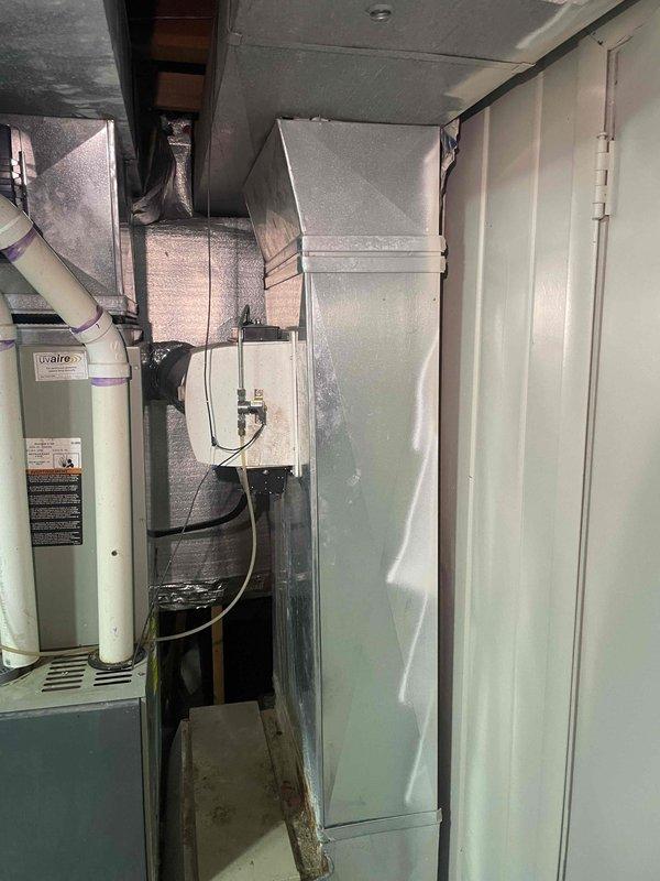 Completed on-site assessment and provided replacement estimate for aging air conditioning system over twenty years old. Evaluated existing HVAC equipment including outdoor condensing unit, indoor air handler, and associated ductwork and drainage systems in basement utility area. Documented current system configuration with comprehensive photographic documentation showing furnace/air handler unit, plenum connections, flexible and rigid ductwork, PVC condensate drain lines, and overall installation layout to support accurate replacement proposal for immediate system upgrade.