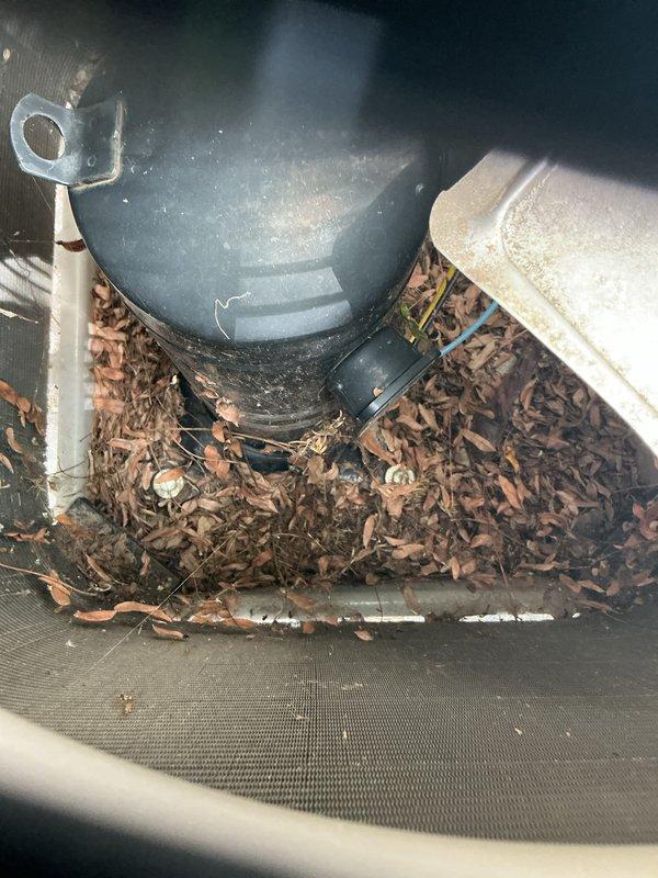 Completed annual cooling maintenance on residential HVAC system. Accessed and inspected evaporator coil assembly, which showed normal condensation and proper operation. Identified significant accumulation of leaves and organic debris around outdoor unit components and condensate drain area. Cleared debris from around equipment to ensure proper airflow and drainage function. Verified condensate drain line routing and connections. All system components inspected and found operational following maintenance procedures.