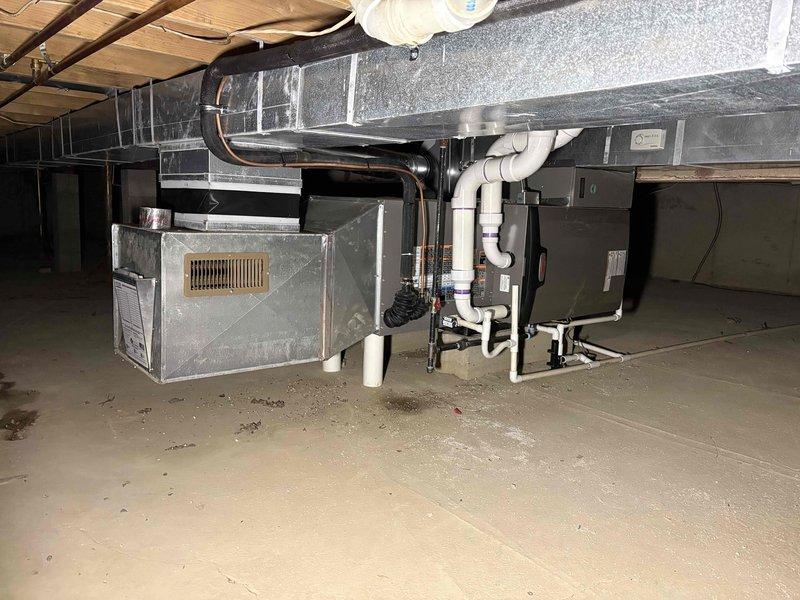 Completed full HVAC system installation in basement consisting of a 90,000 BTU furnace and 3-ton air conditioning unit configured for right-side placement. Installed complete ductwork system including rigid rectangular metal ducts and flexible insulated ducting with proper connections to air handler. Ran white PVC venting pipes from furnace with appropriate joints and purple primer application, routing pipes vertically and horizontally for proper exhaust. Connected humidifier to system and completed all necessary electrical wiring along ceiling joists. Reconnected all components to existing infrastructure and verified proper drainage with condensate lines. All mechanical permits obtained prior to installation and system positioned according to specifications in residential basement space with exposed joists.