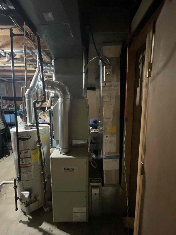Responded to cooling failure complaint on 14-year-old air conditioning system that had received 3 lbs of refrigerant charge from another contractor one month prior with no lasting improvement. Performed comprehensive diagnostic evaluation to provide second opinion after previous company deemed system unrepairable. Assessed outdoor condensing unit, indoor evaporator coil, refrigerant circuit integrity, and overall system performance. Documented existing equipment configuration including Gibson furnace, electrical panel with Generac transfer switch integration, and complete HVAC installation in basement utility area. Provided full system replacement estimate based on findings and system age.