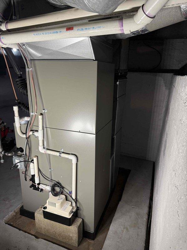 Completed full HVAC system installation including a 70,000 BTU furnace and 2-ton air conditioning unit. Furnace was installed in basement utility area on condensate pan with proper PVC venting and drainage systems, including condensate pump installation. AC condenser unit was positioned on concrete pad on right side of residence with electrical disconnect and proper refrigerant line connections. All necessary mechanical permits were obtained prior to installation, and system was fully reconnected and commissioned for operation.