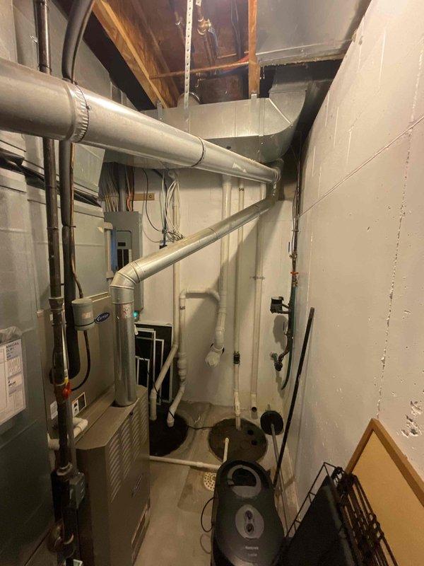 Conducted comprehensive assessment of existing HVAC system for full replacement estimate. Inspected 20-year-old furnace and air conditioning unit located in residential basement mechanical room, documenting current equipment configuration, ductwork layout, venting systems, and spatial constraints. Evaluated electrical service, gas connections, condensate drainage, and existing infrastructure to determine requirements for new equipment installation. Photographed current system components including furnace, water heater placement, PVC venting, copper refrigerant lines, and overhead ductwork distribution to provide accurate replacement specifications and identify any necessary modifications for updated equipment.