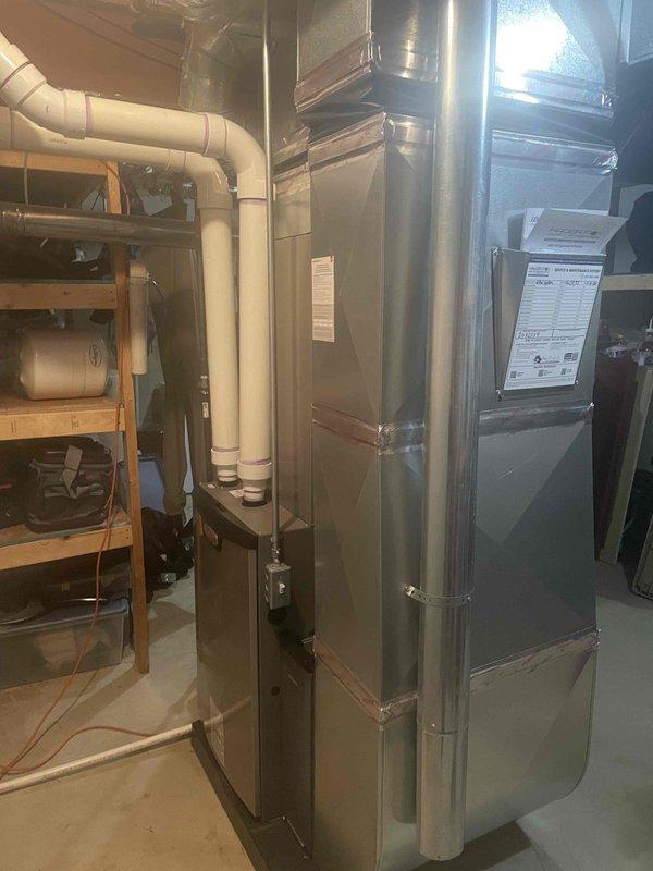 Successfully completed installation of a complete HVAC system including a 90,000 BTU furnace and 3-ton air conditioning unit with rear discharge configuration. The new equipment was installed in the basement utility area with proper venting via PVC piping, ductwork connections, and a Lennox digital thermostat mounted for system control. All mechanical connections were completed, permits were obtained, and the system was tested and commissioned for operation.