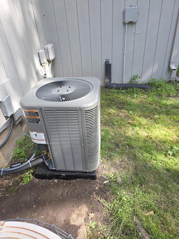 Completed installation of 2-ton air conditioning system with evaporator coil. Installed Ruud furnace unit in basement mechanical space with proper supply and return ductwork connections, ensuring appropriate clearances from combustible materials. Mounted outdoor condenser unit on concrete pad with electrical disconnect box, connected refrigerant lines via wall penetrations using white PVC conduit. Verified all connections, tested system operation, and confirmed proper airflow through ductwork. Installation completed per mechanical permit requirements with rear placement configuration and reconnection of existing electrical service.