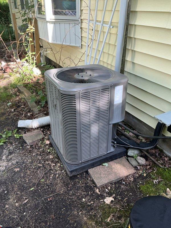 Responded to service call for Lennox model 13ACXN030-230-24 air conditioning unit (serial number 1919K28788) that was reported as turning on. Performed diagnostic inspection of 6-year-old outdoor condensing unit containing R-410A refrigerant with factory charge of 5 lbs 2 oz. Inspected unit exterior, verified proper condensate drainage through white flexible drain line, checked electrical connections and conduit at unit base, and documented equipment specifications and current operating condition. Unit found to be functioning as designed with no immediate repairs required at time of inspection.