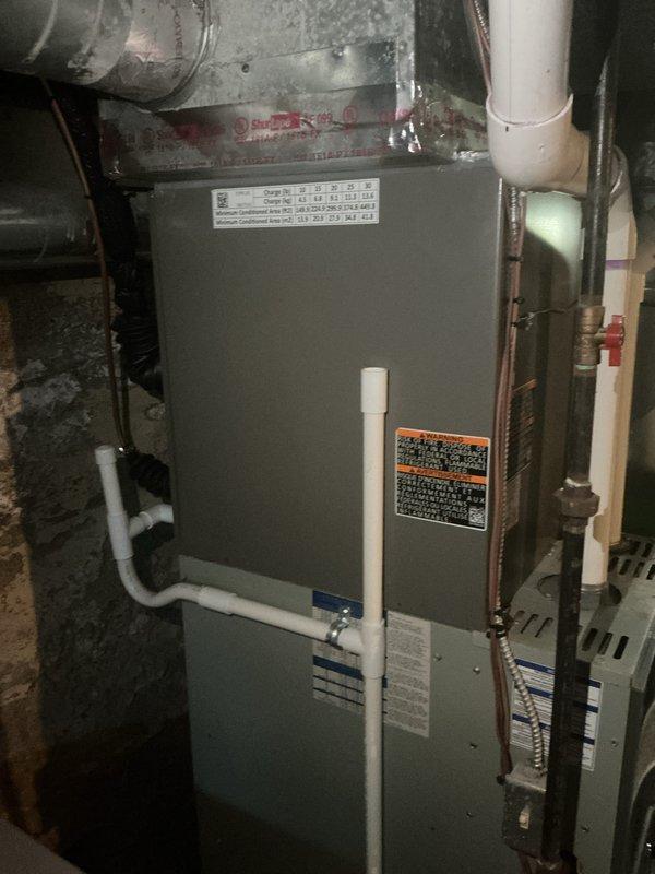 Completed routine Air Care Cooling maintenance inspection on residential HVAC system. Inspected gray two-tone furnace unit, verified all warning labels and specifications were properly affixed, and confirmed white PVC exhaust and intake venting connections were secure. Examined copper piping, metal ductwork connections, gas line with red valve handle, and flexible black ductwork for proper operation. All equipment found to be in normal operational condition with no service needs identified at this time.