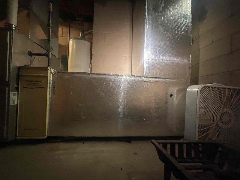 Provided estimate for complete air conditioning system replacement in basement location. Existing 35-year-old unit is non-operational and requires full replacement. Assessment included inspection of existing ductwork system, which shows evidence of deterioration and potential microbial growth along seams and joints that may require remediation or replacement during installation. Documented existing HVAC infrastructure including furnace/air handler and horizontal supply ductwork with foil insulation running through floor joists. Service credit applied toward future equipment installation.