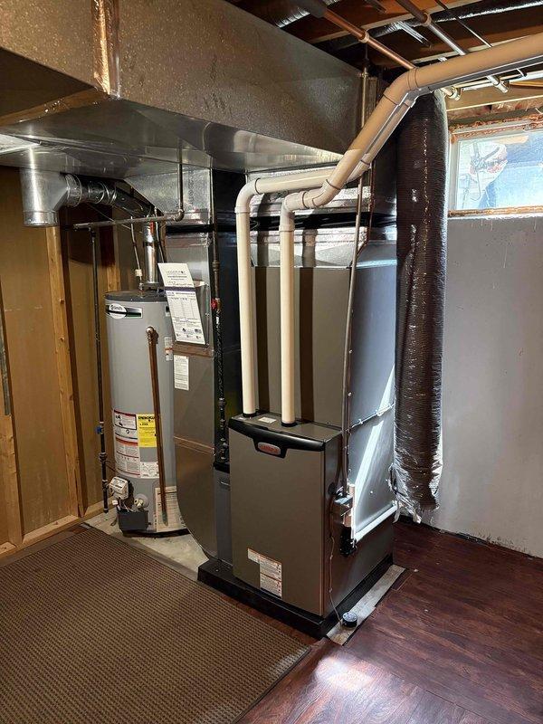 Completed full HVAC system installation in residential basement including 90,000 BTU furnace and 3.5-ton air conditioning unit with evaporator coil. Positioned new furnace on platform base with proper venting using white PVC piping, connected supply and return ductwork with insulated flex duct, and installed left-side configuration as specified. Reconnected all electrical components, tested system operation for proper heating and cooling functionality, and ensured all connections meet code requirements per mechanical permit specifications.