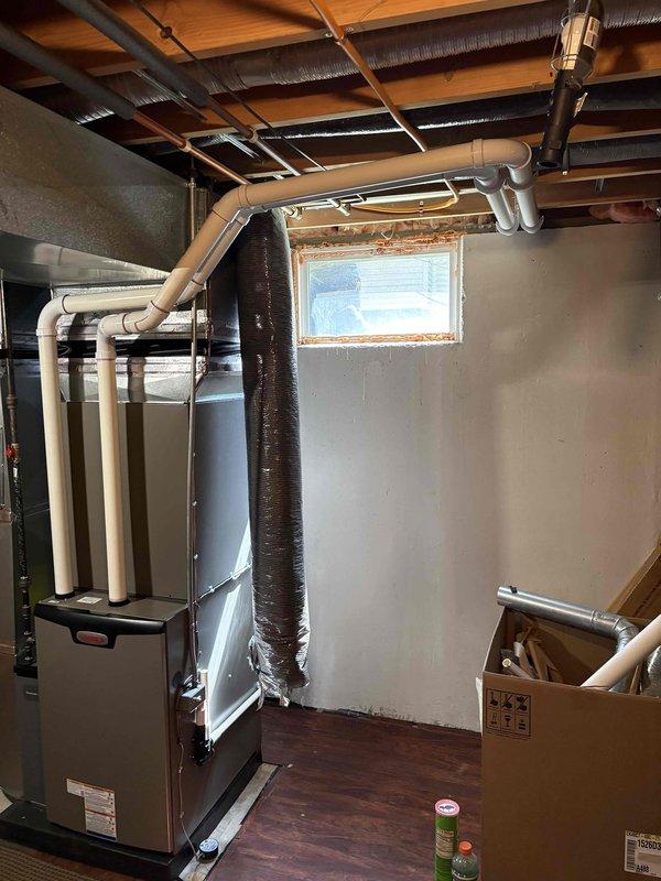 Completed full HVAC system installation in residential basement including 90,000 BTU furnace and 3.5-ton air conditioning unit with evaporator coil. Positioned new furnace on platform base with proper venting using white PVC piping, connected supply and return ductwork with insulated flex duct, and installed left-side configuration as specified. Reconnected all electrical components, tested system operation for proper heating and cooling functionality, and ensured all connections meet code requirements per mechanical permit specifications.