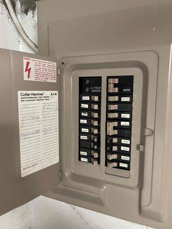 Conducted comprehensive HVAC system evaluation for non-operational furnace and air conditioning system in residential bungalow with forced air distribution and natural gas heating. Assessed existing basement-installed equipment, electrical panel configuration showing Cutler-Hammer load center with proper circuit distribution, and inspected ductwork plenum assembly including main supply trunk and distribution system. Documented current system conditions through photographic evidence of electrical service panel and existing HVAC ductwork installation to support full system replacement estimate for homeowner consideration.