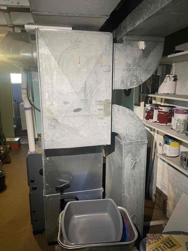 Conducted on-site evaluation for central air conditioning system installation at property with no existing AC system in place. Assessed current HVAC infrastructure including existing air handler unit and furnace with ductwork configuration in basement mechanical space. Documented equipment layout, ductwork connections, and available installation points to provide comprehensive estimate for new central air system installation and integration with existing forced air heating system.