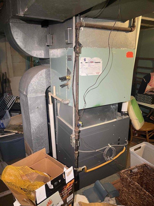 Conducted on-site evaluation for central air conditioning system installation at property with no existing AC system in place. Assessed current HVAC infrastructure including existing air handler unit and furnace with ductwork configuration in basement mechanical space. Documented equipment layout, ductwork connections, and available installation points to provide comprehensive estimate for new central air system installation and integration with existing forced air heating system.