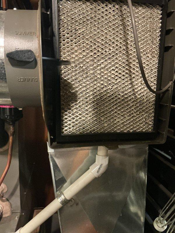 Completed comprehensive ComfortGuard maintenance package including full system inspection and component servicing. Inspected humidifier system with evaporator pad showing typical mineral deposits from normal operation; verified water distribution system and collection pan functioning properly. Replaced air filter with accumulated particulate buildup to restore proper airflow and system efficiency.