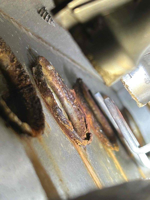 Responded to no cooling complaint with coils iced over affecting entire home. Upon inspection, discovered 12-year-old air handler with significant rust and corrosion on evaporator coil components. Documented equipment condition with photos showing advanced deterioration of coil fins and tubing. System age and extent of corrosion indicate replacement recommended over repair. Advised customer of findings per their request for notification if full unit replacement needed.